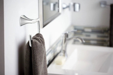 Wall-mounted bathroom faucet and towel holder in modern bathroom setting with mirror