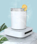 Keep Your Sip Game Strong With This Electric Cup Warmer And Chiller Featuring Three Auto Timer Modes for Piping Hot Coffee or Ice Cold Drinks Portable Desktop Cooler on a marble surface with a chilled cup.