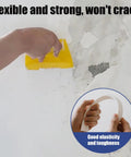 Person using All In One Wall Repair Kit With Easy To Use Putty 500G Quick Drying Filler For Cracks In Walls Ceilings Drywall Concrete And Exterior Waterproof And Long Lasting Home DIY Must Have on a cracked wall with a yellow scraper, demonstrating flexibility and elasticity.