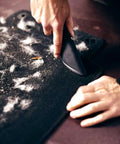 Hands using Fur Remover Pro II Two Point Zero With Fang Adapter For Dogs And Cats Vacuum Hair Attachment on car mat.