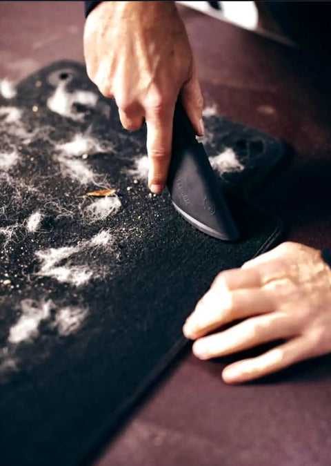 Hands using Fur Remover Pro II Two Point Zero With Fang Adapter For Dogs And Cats Vacuum Hair Attachment on car mat.