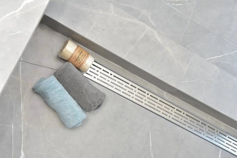 Top Shelf Heavy Duty SS304 Stainless Steel Linear Shower Drain With Integrated Hair Trap Anti Clog Catcher Rust Proof Corrosion Resistant Construction Perfect For Modern Bathroom Upgrades Sleek Design 59 Inch Span For Pro Results with towels on tile.