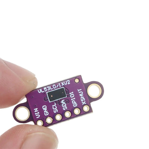 Top Shelf Vl530x Time Of Flight Laser Range Finder Breakout Module Purple Pcb Board I2c Interface viewed close-up in a hand.