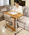Sleek Rolling Laptop Desk With Locking Casters And Adjustable Tilt Tray Table For Home Office Bedroom Couch Computer Stand Fast Setup Portable Workspace Game Changer White 60X40 in use with a person writing.