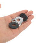 Hand holding Universal Motorcycle Pedal Spacer Washers, a mix of black and silver washers for noise reduction and vibration dampening.