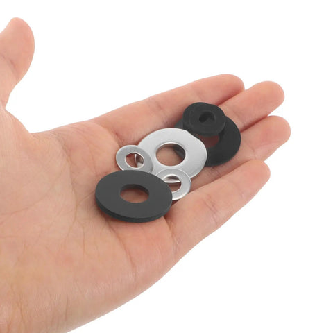 Hand holding Universal Motorcycle Pedal Spacer Washers, a mix of black and silver washers for noise reduction and vibration dampening.