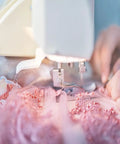 Close-up of sewing machine using Two Piece Hump Jumper Sewing Tools Set For Quilting And Hemming on pink lace fabric