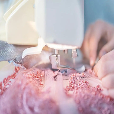 Close-up of sewing machine using Two Piece Hump Jumper Sewing Tools Set For Quilting And Hemming on pink lace fabric