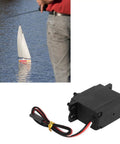 Beefy Metal Gear Sail Winch Servo Motor With Alloy Gears Analog Servo in black, shown near a model sailboat on water surface.
