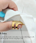 Close-up of hand sewing with 37 Piece Hand Sewing Tool Set With Big Eye Stainless Steel Needles, gold thimble, and thread on fabric.