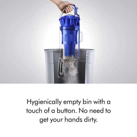 Dyson Ball Animal upright vacuum cleaner in blue being hygienically emptied into a trash bin.