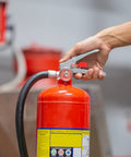 Top Grade 2000 Pack Fire Extinguisher Tamper Seals Plastic Safety Lock Pins Red Security Zip Ties For Office Industrial Equipment Management Heat Resistant Universal Fit with hand on red fire extinguisher nozzle.
