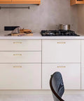Front view of a modern kitchen with Ten Pack 5 Inch Champagne Bronze Cabinet Handles In Solid Zinc Alloy on white cabinets.