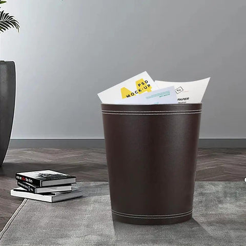 Classic Pu Leather Round Trash Can In Brown For Bathroom Powder Room Kitchen Office And Hotel Use Durable PU Exterior With Non Woven Liner And White Stitching Dope Modern Wastebasket For Home shown in modern room.