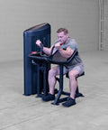Man using Pro Clubline Bicep Preacher Curl Machine With Multi Grip Revolving Handle Bar And 235 Pound Weight Stack in home gym