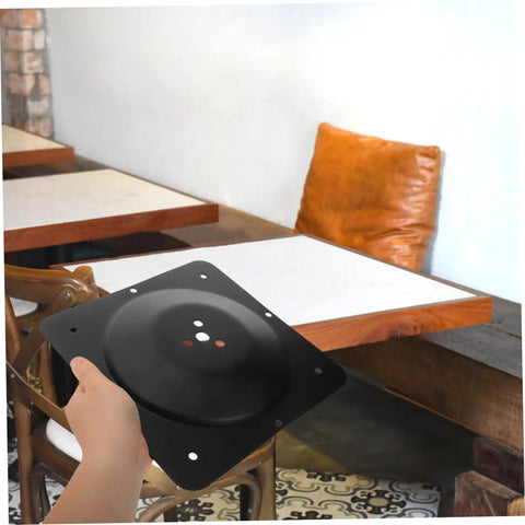 Built Tough Cast Iron Table Leg Brackets With Five Hole Mounting Plates displayed in hand against a wooden table backdrop.