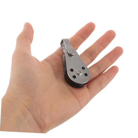 Person holding Heavy Duty Stainless Steel Pulley Block Set With Bearings For Boats Kayak And Sailing Gear Four Pack Rope Pulley