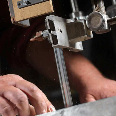 Close-up of hands adjusting the Premium 62 Inch Bandsaw Blade 1/4 X 6 Tpi Direct Fit For 9 Inch Tools in a bandsaw.