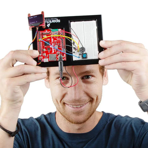MicroPython Inventor Kit With RP2350 IoT RedBoard For Makers 5 Guided Projects And 16 Circuits With OLED Display Motors Sensors Robot Build And A Solderless STEM Kit For Hands On Learning, man holding assembled board with OLED display