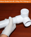 Hand holding 2 Inch PVC Fittings 3 Way Elbow Connectors Four Pack Furniture Grade Heavy Duty For DIY Furniture Frames UV Resistant.