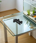 Fish Tank Water Hose Clip Holder For Aquarium Hose Clamp Made Of ABS Plastic on glass table near aquarium