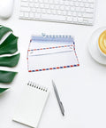 Retro Airmail Envelopes Pack For Invitations And Letters Easy To Use Air Mail Style Envelopes For Home School And Office Available In 5 10 Or 20 Pack With Classic Red White Blue Guide Lines on a desk with keyboard, notepad, pen, and coffee cup.