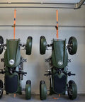 Two Smooth Operator Electric Single Rider Golf Carts With Foldable Four Wheel Chassis Hanging in a garage.