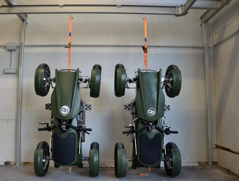 Two Smooth Operator Electric Single Rider Golf Carts With Foldable Four Wheel Chassis Hanging in a garage.