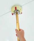 Ladder Free Smoke Transducer Assembly Tool With Heavy Hitter Sensor Head For High Ceiling Detectors, holding golden pole with sensor grip.