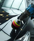 Cordless drill using Forced Dual Action Polisher Adapter Kit With Three Polishing Pads on car hood for polishing and scratch removal