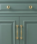 Solid Brass Cabinet Pull And Drawer Knob With Modern Grooved Base Design in antique brass finish on green kitchen cabinet