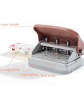 Pink Handheld 3 Hole Paper Punch with ABS and iron construction, showing top cover handle and chip catcher for office use.
