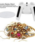 Solar Powered Jewelry Display Stand With 360 Degree Rotating Turntable And Blue LED Lights Electric Base For Showcase Counter Merchandise Presentation Cool Gift Idea with assorted rings and necklaces.