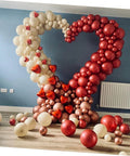 Front view of LABRIMP heart-shaped balloon arch made from cream and red pastel balloons for wedding decor.