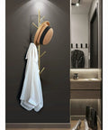 Sleek Modern Wall Mount Coat Rack Heavy Duty Entryway Storage Hook holding a white coat and a hat, angled view against a dark wall.