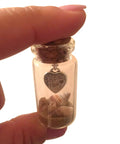 Close-up of a cork top bottle with sand and shells, featuring a heart charm, connected with a mini screw eye pin from the 300Pcs set.
