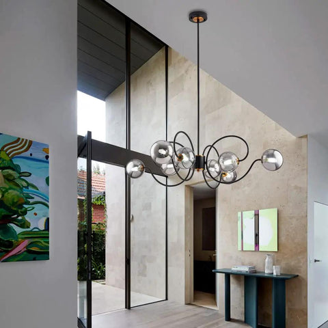 Mid Century Modern Black Eight Light Glass Globe Sputnik Chandelier in living room with high ceiling, smoke gray globes.