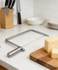 Rock Solid Stainless Steel Cheese Slicer Accessories For Hard Cheddar And Butter No Sweat Wire Cutter on wooden board.
