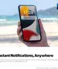 Smartphone displaying leak alert from FlowSmart All-In-One Smart Water Meter, held at the beach with ocean in background.
