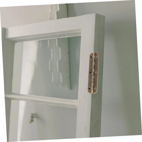 Side view of white wooden cabinet door with brass piano hinge along edge.
