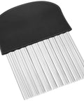 Close-up of a large stainless steel crinkle cutter with ribbed blades and black ergonomic handle.