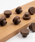 Top Shelf Mid Century Modern Walnut Mushroom Cabinet Knobs Slick Round Drawer Pulls on wood background, set of eight.