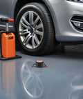 Slap This Auto Fire Suppressant Disc Straight Up On Dashboards Or Beneath Hood Panels Where Heat Spikes triggers on garage floor next to car tire.