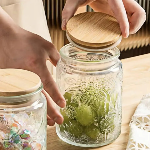 Hands lifting bamboo lid of Vintage Glass Jar With Lid 23.7oz Airtight Food Storage for Coffee, Tea, Sugar and Snacks.