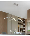 Upgrade Your Digs With This Slick Wave Shaped LED Pendant Light Boasting A Premium Gold Chrome Plated Finish Perfect For Restaurants Kitchens And Chill Dining Spaces, hanging above a modern kitchen island.