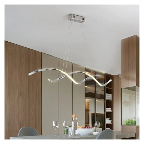 Modern Wave LED Pendant Light Featuring Brushed Gold Finish And Clean Geometric Lines Ideal For Commercial Kitchens Dining Rooms And Loft Spaces Tough Aluminum Construction delivering a warm glow above a kitchen island.