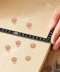 Measuring a wooden board with khaki plugs for 50 Piece Wooden Plug Replacement Set For Woodworking And Home Decor
