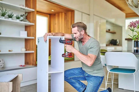 Man using Rock Solid 18V Cordless Drill Driver With Kickass 45 Nm Torque to assemble furniture in a modern home.