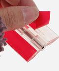 Clear Self Adhesive Acrylic Hinges For Cabinet Doors And Small Boxes 45x34mm with red adhesive backing being peeled off