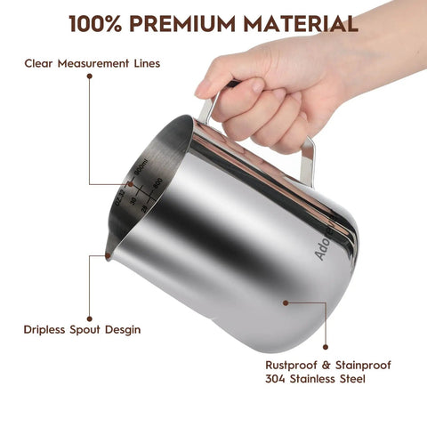Hand holding 32oz Milk Frothing Pitcher With Latte Art Pen For Espresso Machines And Coffee Bar Stainless Steel Milk Jug with clear measurements.
